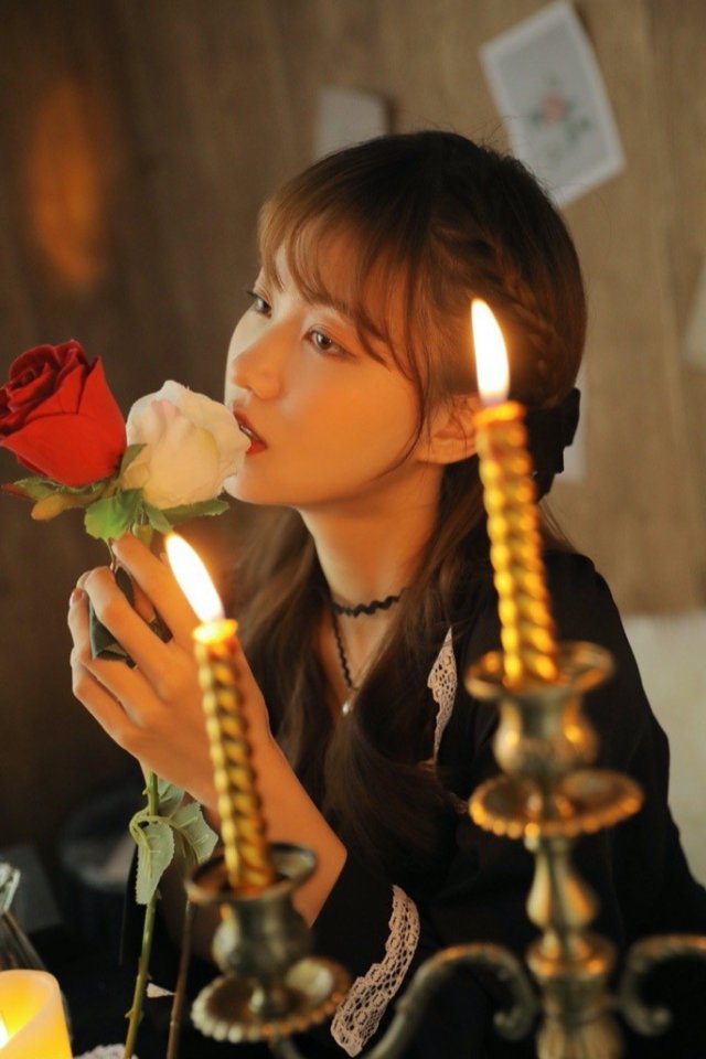 The beautiful and lovely girl in the candlelight is quiet, elegant and charming